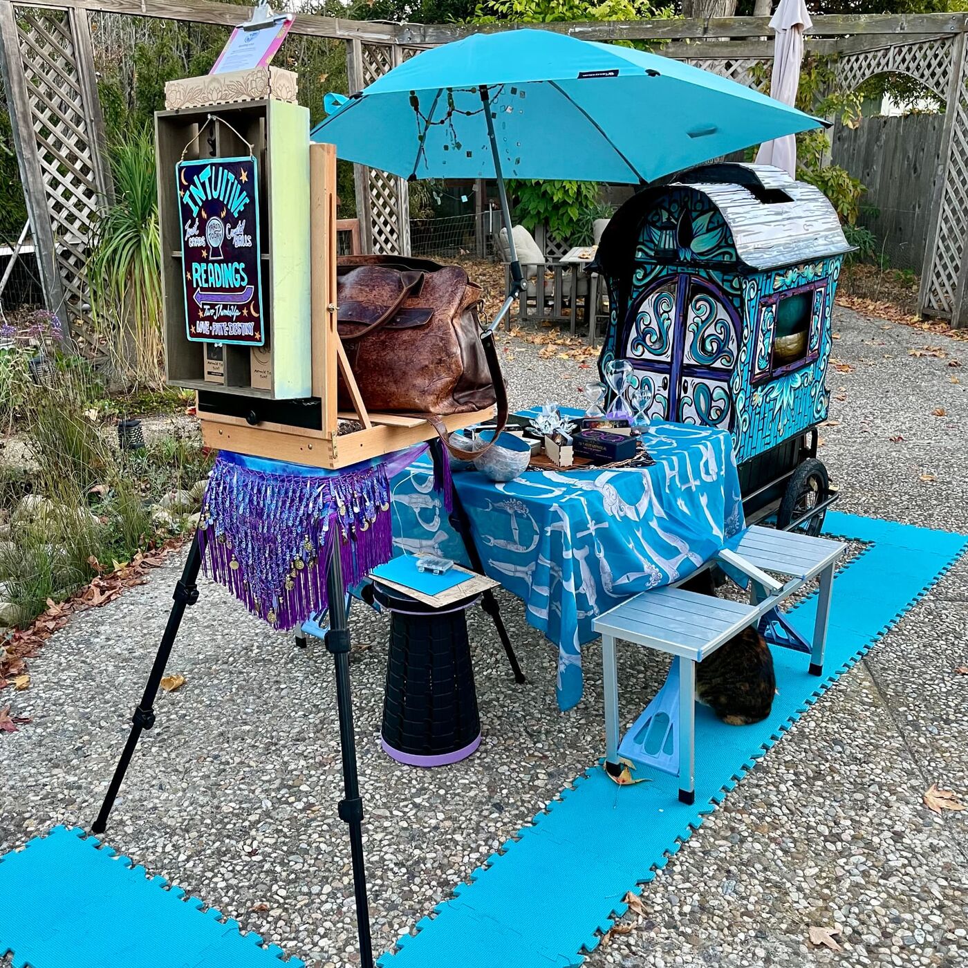 Mitra's outdoor reading booth with a teal umbrella and painted signs